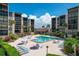 Community pool and outdoor lounge area surrounded by lush greenery and residential buildings at 6480 Midnight Pass Rd # 311, Sarasota, FL 34242