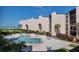 Community pool with ocean view, surrounded by lounge chairs and lush landscaping at 6480 Midnight Pass Rd # 311, Sarasota, FL 34242