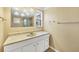 Bathroom featuring a white vanity with marble top and a decorative mirror at 6760 14Th S St, St Petersburg, FL 33705