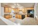 Functional kitchen with wood cabinets, black appliances, and wood-style floors for easy maintenance at 6760 14Th S St, St Petersburg, FL 33705