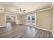 A spacious living room featuring wood-look floors, ceiling fan, and double doors to the backyard at 6760 14Th S St, St Petersburg, FL 33705