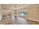 Bright living room featuring wood flooring, a bay window, and a mirrored wall for added space at 6760 14Th S St, St Petersburg, FL 33705