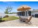 Charming outdoor patio with brick pavers, seating, and a cozy thatched umbrella for comfortable outdoor living at 6841 Roxbury Dr, Sarasota, FL 34231