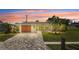 Inviting single-story home featuring a well-manicured lawn, mature palm trees, and a paver driveway at 6841 Roxbury Dr, Sarasota, FL 34231