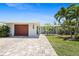 Charming single-story home featuring a well-manicured lawn, and paver driveway leading to the attached garage at 6841 Roxbury Dr, Sarasota, FL 34231