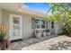 Cozy front porch area with neutral chairs and tables, enhanced by a wreath on the front door at 6841 Roxbury Dr, Sarasota, FL 34231
