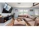 Comfortable living room with a large sectional sofa, modern TV console, and bright natural light at 6841 Roxbury Dr, Sarasota, FL 34231