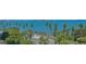 Aerial view showcasing a coastal road lined with palm trees and lush greenery with an ocean view at 688 Golden Gate Point # 701, Sarasota, FL 34236