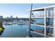 Exterior view of modern condo balconies overlooking a marina, with city skyline in the background and partial blue sky at 688 Golden Gate Point # 701, Sarasota, FL 34236