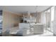 Modern kitchen featuring white cabinets, wood accents, pendant lighting, and a large island at 688 Golden Gate Point # 701, Sarasota, FL 34236