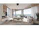 Bright living room with floor-to-ceiling windows, modern decor, fireplace, and stunning ocean view at 688 Golden Gate Point # 701, Sarasota, FL 34236