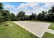 Outdoor basketball court on grassy field surrounded by mature trees, enhancing the appeal of community amenities at 6907 47Th E Ct, Ellenton, FL 34222