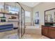 Bright bathroom featuring a soaking tub, glass shower, dark vanity with a sink, and a shelving unit with towels at 6907 47Th E Ct, Ellenton, FL 34222