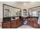 Bathroom featuring a double vanity with dark wood cabinets, black granite countertops, and decorative shelving at 6907 47Th E Ct, Ellenton, FL 34222