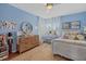 Blue bedroom featuring a large window, neutral curtains, hardwood floors, and decorated with toys and art at 6907 47Th E Ct, Ellenton, FL 34222