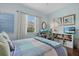 Bright bedroom with a large window, neutral curtains, hardwood floors, and light blue walls creating a relaxing atmosphere at 6907 47Th E Ct, Ellenton, FL 34222