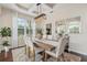 Elegant dining room with a modern light fixture, large mirrors, and ample seating at 6907 47Th E Ct, Ellenton, FL 34222