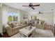 Bright living room features hardwood floors, neutral couches, natural lighting, and views into the home office at 6907 47Th E Ct, Ellenton, FL 34222