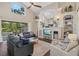 Spacious living room with a fireplace, built-in shelving, and views of the pool at 6907 47Th E Ct, Ellenton, FL 34222
