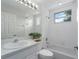 Bright bathroom features white cabinets, tiled walls, garden tub and window at 7035 Scrub Jay Way # 202, Bradenton, FL 34203