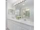 Bathroom featuring double sinks, a large mirror, and a full-sized shower with glass doors at 7035 Scrub Jay Way # 202, Bradenton, FL 34203