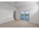 Bedroom featuring neutral carpet, large window with water view, and access to balcony at 7035 Scrub Jay Way # 202, Bradenton, FL 34203