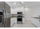 Modern kitchen featuring stainless steel appliances, granite countertops, and white cabinets at 7035 Scrub Jay Way # 202, Bradenton, FL 34203