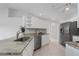 Well-lit kitchen featuring granite counters, stainless appliances, white cabinets, and tile flooring at 7035 Scrub Jay Way # 202, Bradenton, FL 34203