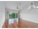 Bright living room with hardwood floors, ceiling fan, and sliding glass doors to the lanai at 7035 Scrub Jay Way # 202, Bradenton, FL 34203