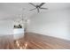 Open-concept living room featuring hardwood floors, modern lighting, and a view of the kitchen at 7035 Scrub Jay Way # 202, Bradenton, FL 34203
