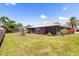 Lush backyard featuring a screened-in lanai, verdant lawn and mature trees, creating a serene and private outdoor oasis at 710 Beverly Rd, Venice, FL 34293