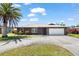 Charming single-story home featuring an attached two-car garage, palm tree, and well-maintained landscaping at 710 Beverly Rd, Venice, FL 34293