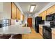 Efficient kitchen with light wood cabinetry, black appliances, and ample countertop space at 710 Beverly Rd, Venice, FL 34293