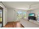 Bright living room with wood floors, neutral paint, and a view of the backyard through a sliding glass door at 710 Beverly Rd, Venice, FL 34293