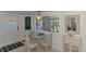 Bright dining area with view, glass table, and wicker accent furniture at 714 N Waterway Dr, Venice, FL 34285