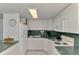 Well-lit kitchen featuring white appliances and cabinetry, complimented by green countertops and tile flooring at 714 N Waterway Dr, Venice, FL 34285