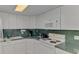 A detailed view of the kitchen with white appliances, green countertops, and ample cabinet space at 714 N Waterway Dr, Venice, FL 34285