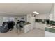 Bright kitchen with white cabinets, green countertops, and tile flooring, open to the living area at 714 N Waterway Dr, Venice, FL 34285
