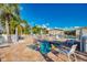 People relaxing in the spa and pool area with lounge chairs and palm trees on a bright, sunny day at 714 N Waterway Dr, Venice, FL 34285