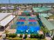 Aerial view of community recreation courts with pickleball, shuffleboard, swimming pool, and lounging at 714 N Waterway Dr, Venice, FL 34285