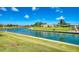 Picturesque waterfront view with grassy banks leading to calm blue water and charming homes in the background at 714 N Waterway Dr, Venice, FL 34285