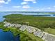 Aerial view of waterfront condos with lush green landscaping, pools, and scenic water views at 76 Tidy Island Blvd, Bradenton, FL 34210