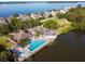 Waterfront community featuring a beautiful pool, clubhouse, and lush landscaping on a sunny day at 76 Tidy Island Blvd, Bradenton, FL 34210