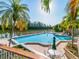 Community pool area with lounge chairs, tables, and a picturesque water view beyond at 76 Tidy Island Blvd, Bradenton, FL 34210