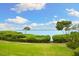 Scenic waterfront view featuring lush green lawns and trees leading to a tranquil body of water at 76 Tidy Island Blvd, Bradenton, FL 34210