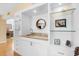 Modern wet bar featuring open shelving, granite countertop, and a round mirror at 76 Tidy Island Blvd, Bradenton, FL 34210