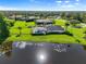 Aerial view of house with screened in pool area, large lawn and lake at 7832 Panther Ridge Trl, Bradenton, FL 34202
