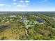 Expansive aerial view of a property nestled among lush greenery and serene lakes, showcasing the home's picturesque setting at 7832 Panther Ridge Trl, Bradenton, FL 34202