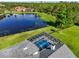 Aerial view of property with a private pool and a picturesque lake view, surrounded by lush greenery at 7832 Panther Ridge Trl, Bradenton, FL 34202