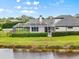 Backyard view of a house with a screened porch and pond, bordered by well-maintained hedges and landscaping at 7832 Panther Ridge Trl, Bradenton, FL 34202